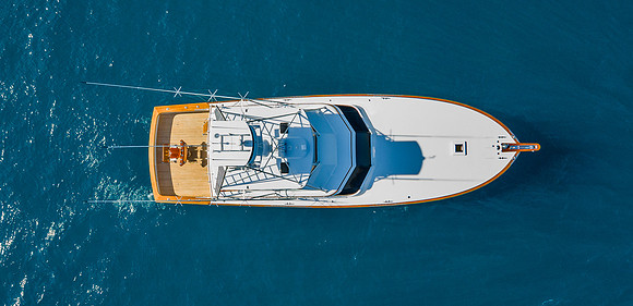 Top-Down Aerial View of a Sportfishing Boat Cruising on Deep Blue Water
