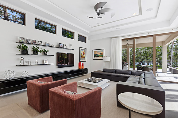 Living Room with Floating Media Wall and Terracotta Accent Chairs Photography | Jupiter, FL