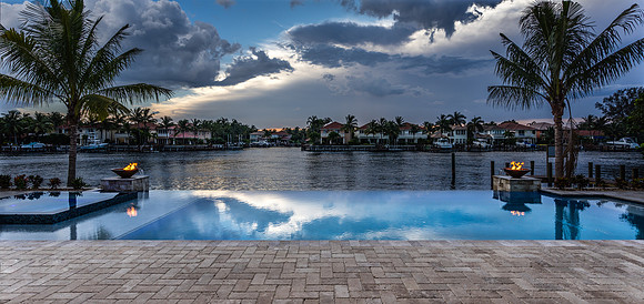 Twilight Waterfront Pool with Fire Bowls and Dramatic Sky Photography | Jupiter, FL