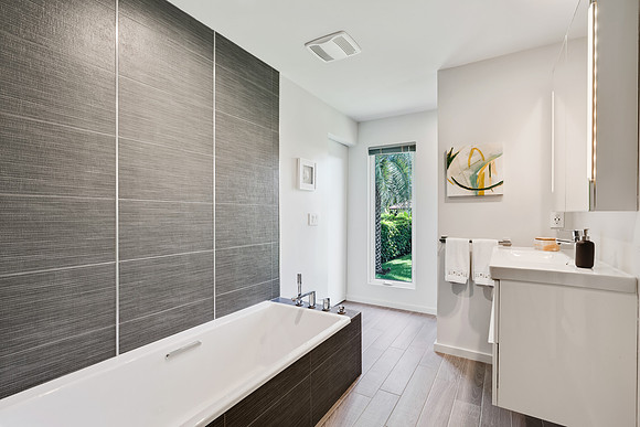 Modern Bathroom with Wood Tile Accent Wall and Soaking Tub Photography | Jupiter, FL
